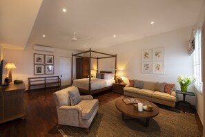 Cozy retreat with a four-poster bed, sofa, and armchair, perfect for relaxing.