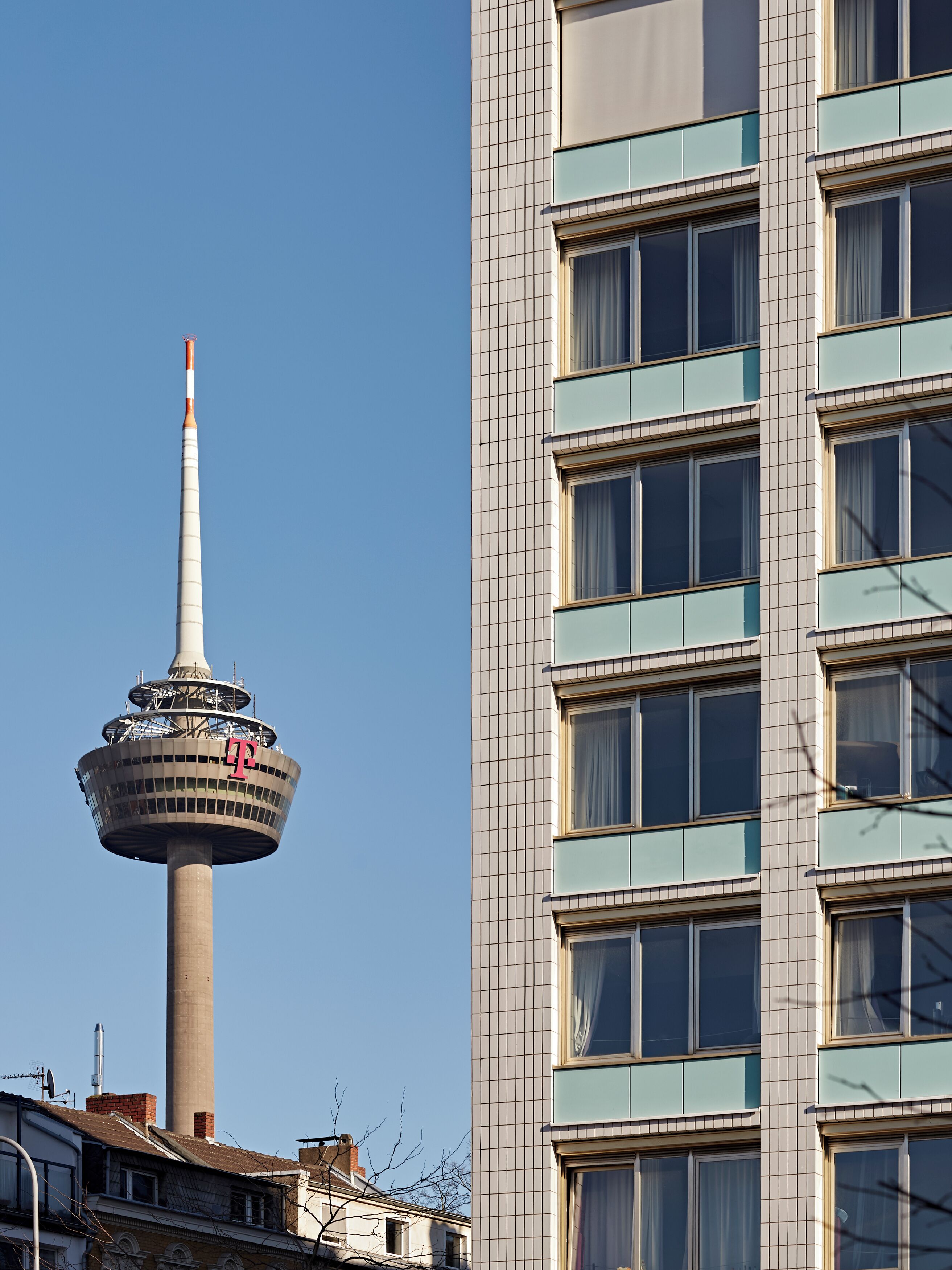 Ein modernes Gebäude mit einem markanten Turm, der ein auffälliges Design und ein großes 'F' an der Seite aufweist.