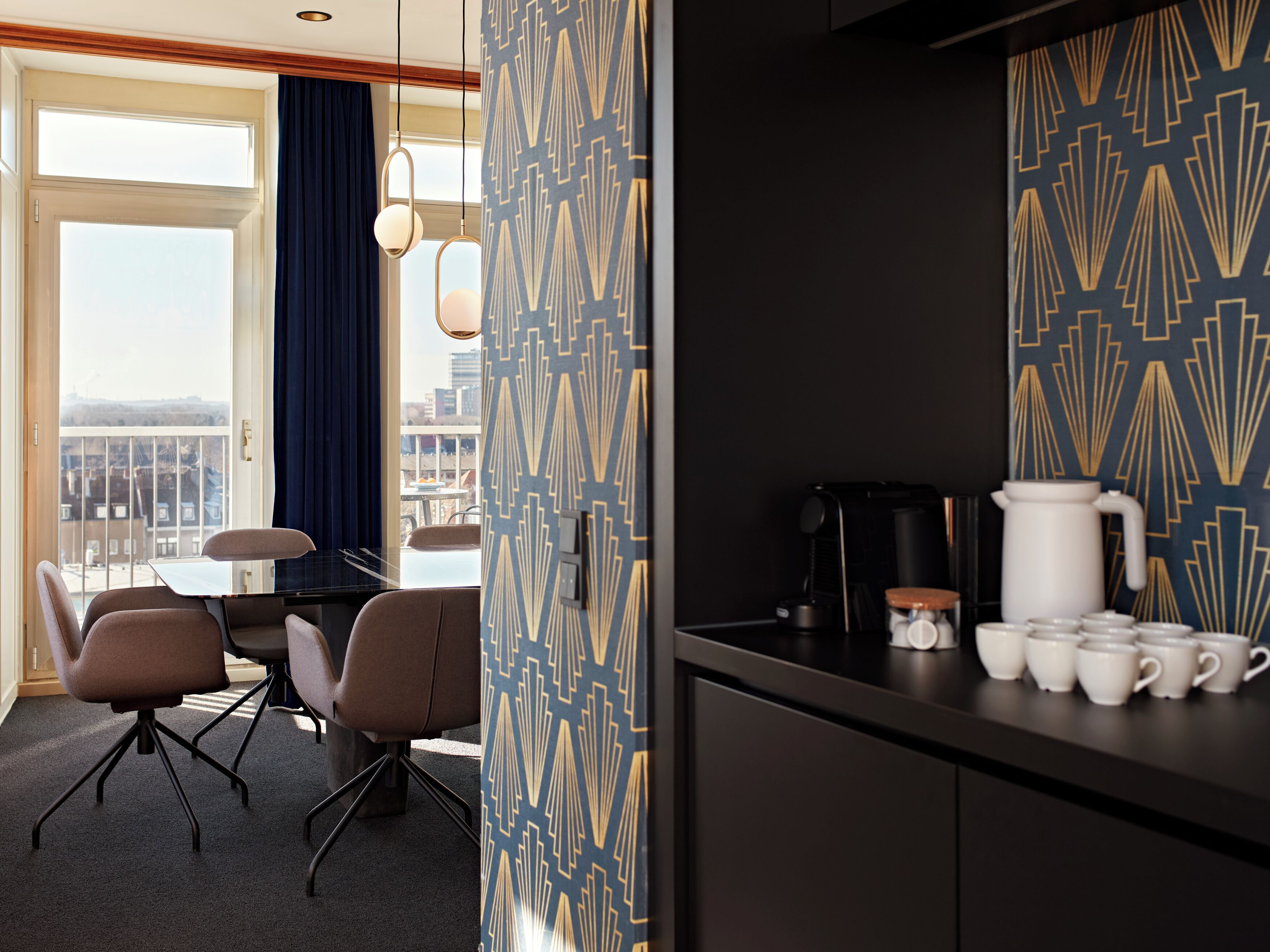 Ein Hotelzimmer mit Balkon, Essbereich und einer Küchenzeile.