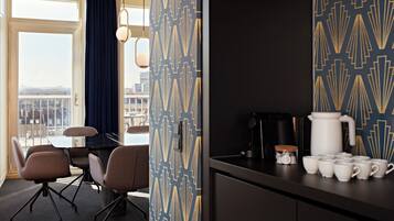 A hotel room with a balcony, a dining area, and a kitchenette.
