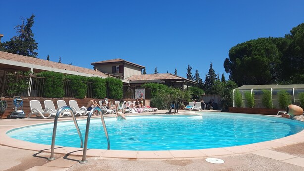 A swimming pool with lounge chairs and a building in the background.