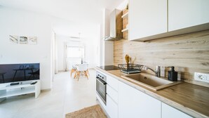 Eine moderne Küche mit weißen Schränken, einer Holzarbeitsplatte und einem eingebauten Kochfeld.