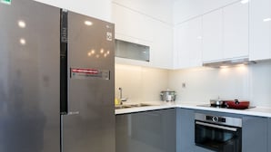 A modern kitchen with stainless steel appliances, a built-in oven, and a compact cooking area. - Stephen's Riverside Apartments (Ho Chi Minh City)
