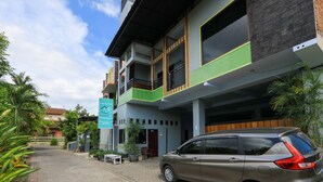 A multi-story building with a car parked in front.