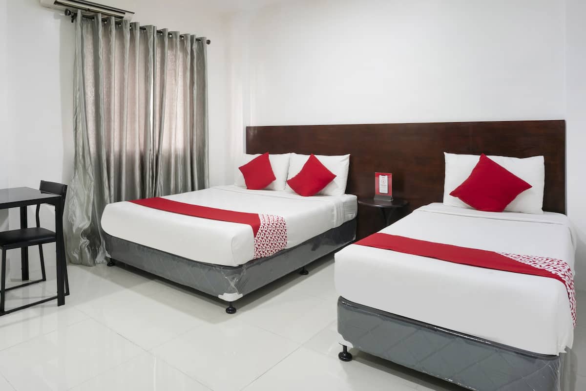 A hotel room with two beds, a desk, and a chair.