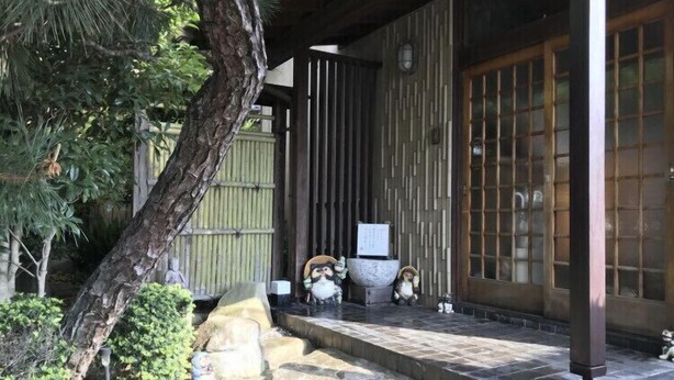 A traditional Japanese building with a wooden exterior, a tiled entrance, and a stone pathway leading to the door. - Ryu (Hatsukaichi)