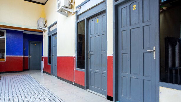 A hallway with doors numbered 2 and 3, a ventilation unit, and a patterned floor. - Hotel O Buana Jaya Guest House (Cilacap)