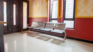 A waiting area with a bench, a door, and patterned walls. - Hotel O Buana Jaya Guest House (Cilacap)