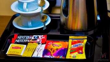 Una bandeja con una cafetera Nescafe, una tetera y diferentes cápsulas de café.