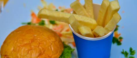 A hamburger and a cup of fries on a plate.
