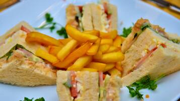 A plate with sliced sandwiches and French fries.