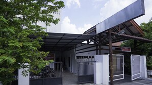 A gated entrance with a covered walkway, a sign indicating 'OYO', and a building in the background. - Hotel O Berkah Residence Syariah (Gresik)