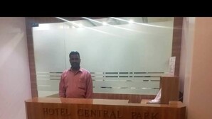 A wooden reception desk with "HOTEL CENTRAL PARK" engraved on it. - Hotel Central Park (Ambernath)