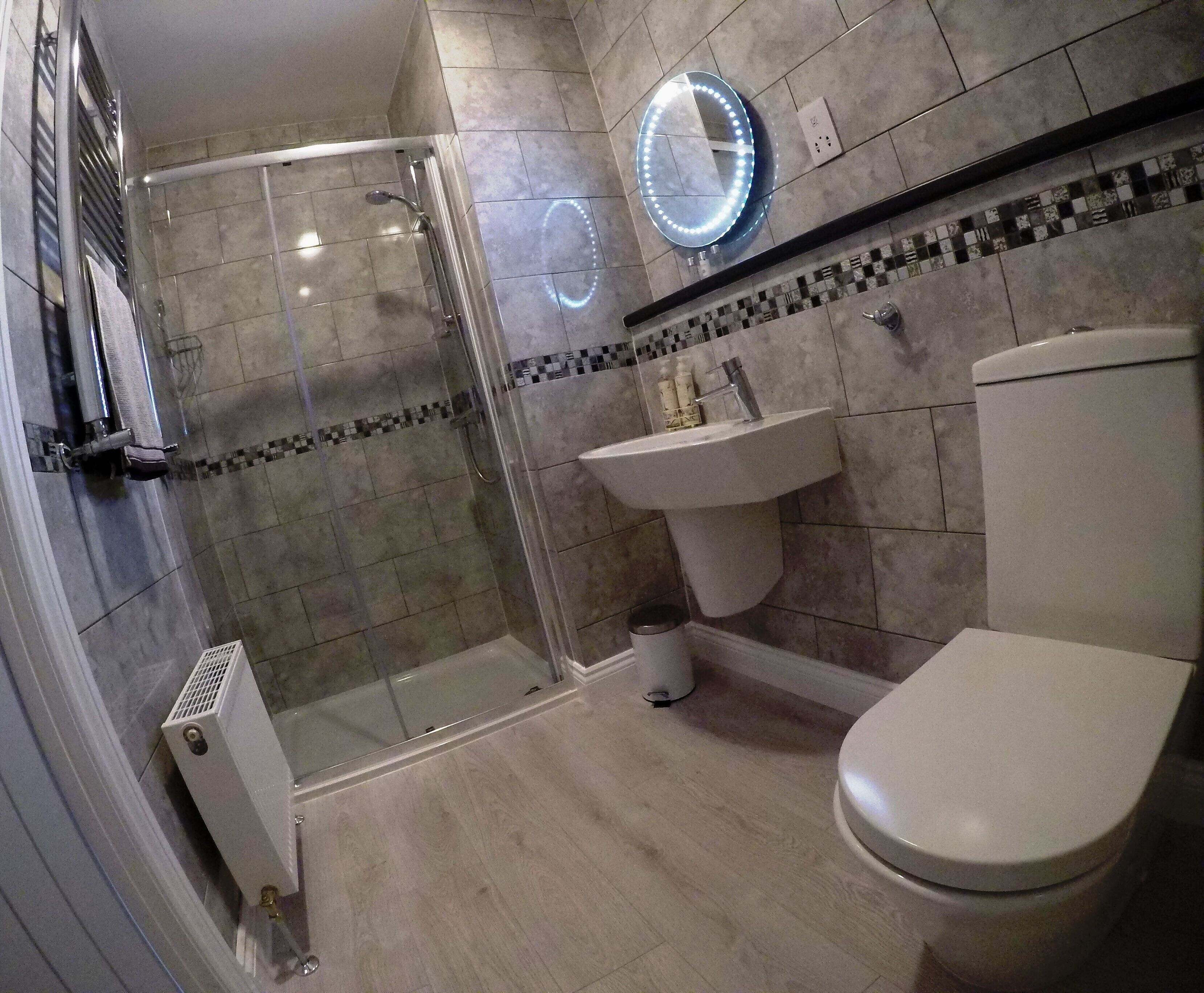 Une salle de bain avec une douche à parois de verre, un lavabo et des toilettes.