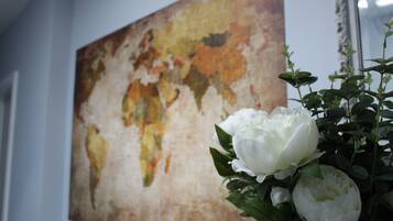 A room with a large world map on the wall and a white flower arrangement.