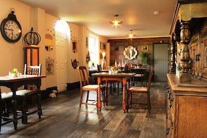 Uma sala de jantar com móveis de madeira, um relógio e um espelho na parede.