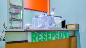 A reception area with a glass display case containing pastries and a fish tank. - Hotel O Gangnam Style Residence (Surabaya)