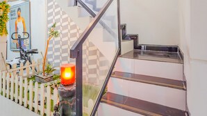 A staircase with a metal handrail and a white picket fence. - Hotel O Gangnam Style Residence (Surabaya)
