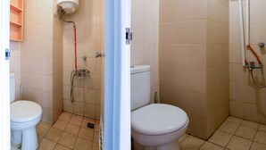 A bathroom with two toilets, a shower, and a water heater. - OYO 2582 Apartemen Serpong Green View (South Tangerang)