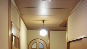 Un pasillo estrecho con puertas de madera y una escalera.