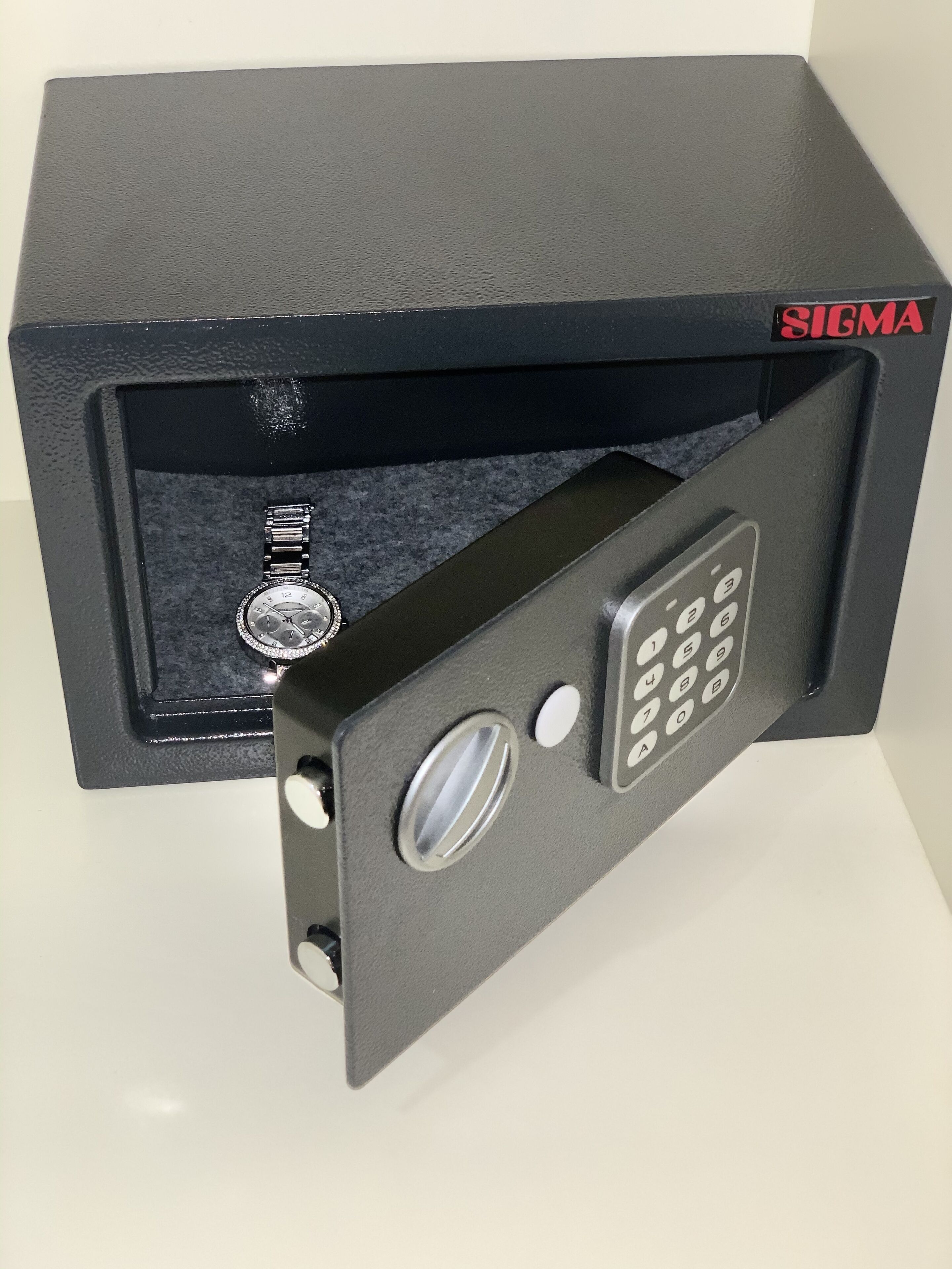 Ein schwarzer Safe mit einer Zahlen-Tastatur und einem Schlüsselloch, platziert in einer schwarzen Box.