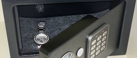 Ein schwarzer Safe mit einer Zahlen-Tastatur und einem Schlüsselloch, platziert in einer schwarzen Box.