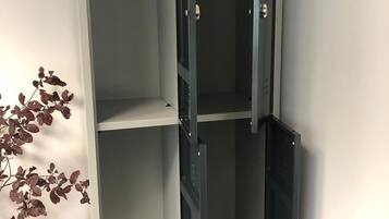 Un vestidor con dos puertas abiertas que muestran estantes vacíos.