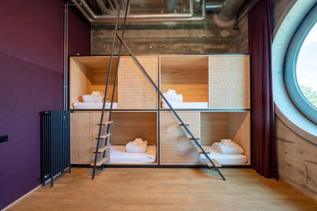 A room with a bunk bed, a ladder, and a radiator.