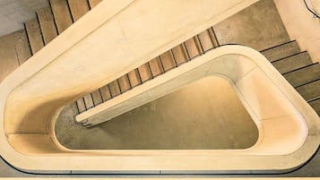 Una escalera de caracol con un diseño único, que presenta un pasamanos continuo y curvado y escalones que ascienden en espiral.