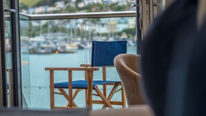 Ein Balkon mit Blick auf einen Hafen und Häuser in der Ferne.