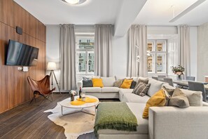 A modern living room with a sofa set, a coffee table, and a leather chair. - Charm APTs in Prague by Michal&Friends (Prague)