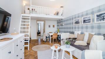 A spacious living area with a loft bedroom, a dining table, and a cozy seating area.