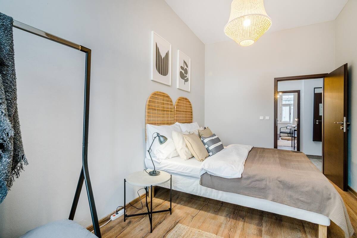 Ein Schlafzimmer mit Bett, Nachttisch, Lampe und einem Bild an der Wand.