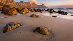 A beach with large rocks and a mountain in the background. - The Jade Estate Somerset West (Cape Town)