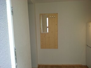A room with a wooden door, a small mirror, and a light switch on the wall. - heidelbed-Ferienwohnung Heidelberg (Heidelberg)
