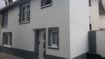 A two-story building with a flat roof, white exterior walls, and dark trim around the windows and door.