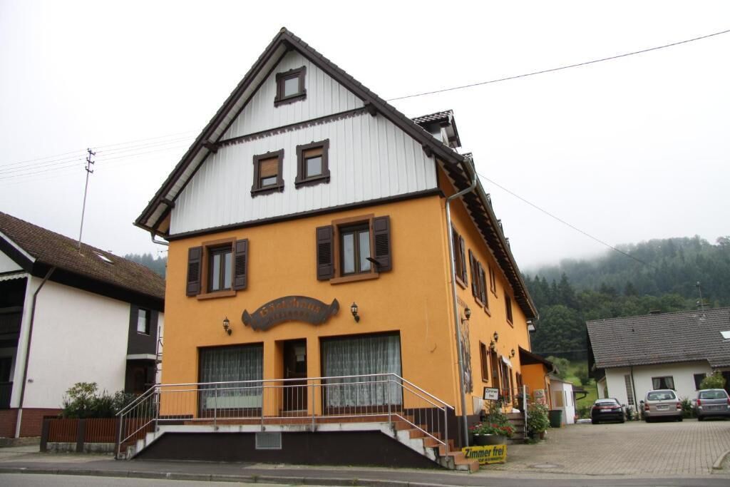A two-story building with a yellow facade and a black roof.