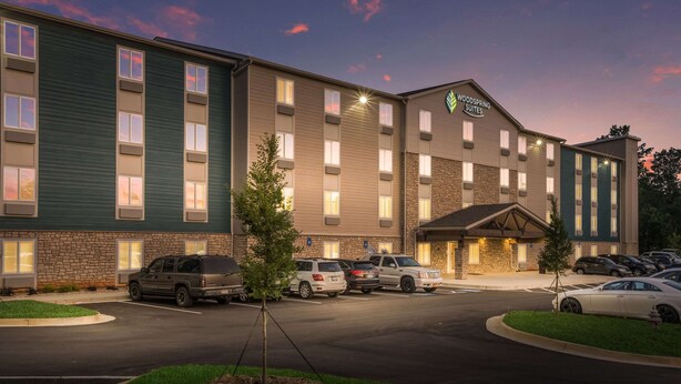 A multi-story hotel with a stone facade and a flat roof. - WoodSpring Suites Atlanta McDonough (McDonough)