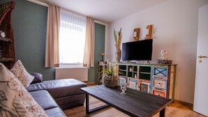 Leilighet, 1. etasje | Oppholdsområde | En 80-centimeters Flatskjerm-TV med Parabol-TV samt TV