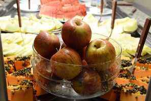 Ein Buffet mit verschiedenen Früchten, darunter Äpfel, Wassermelone und Papaya.