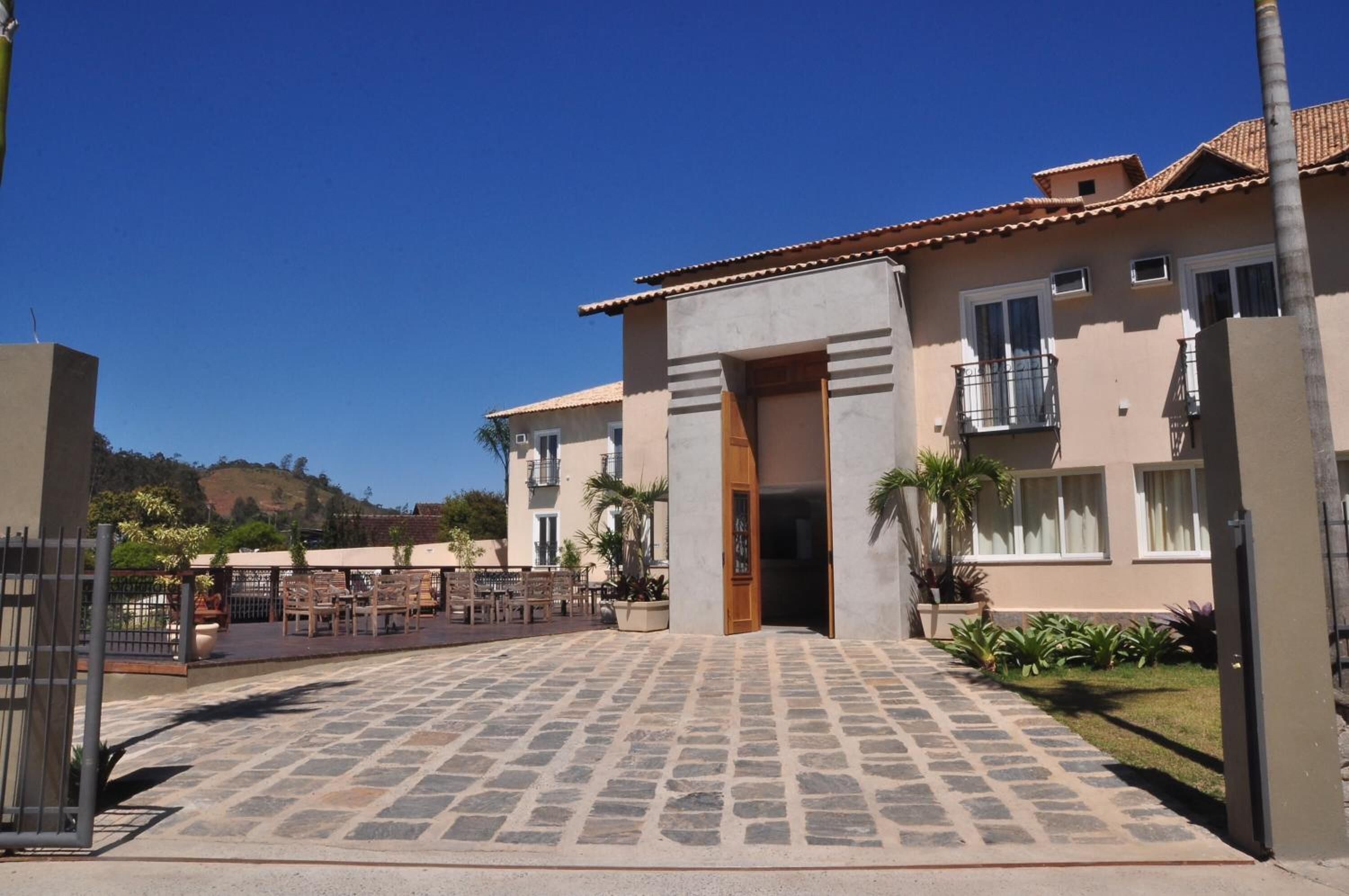 Un edificio con un patio empedrado, una puerta de madera y un balcón.
