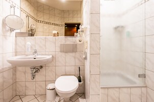 Un baño moderno con lavamanos, inodoro y ducha.