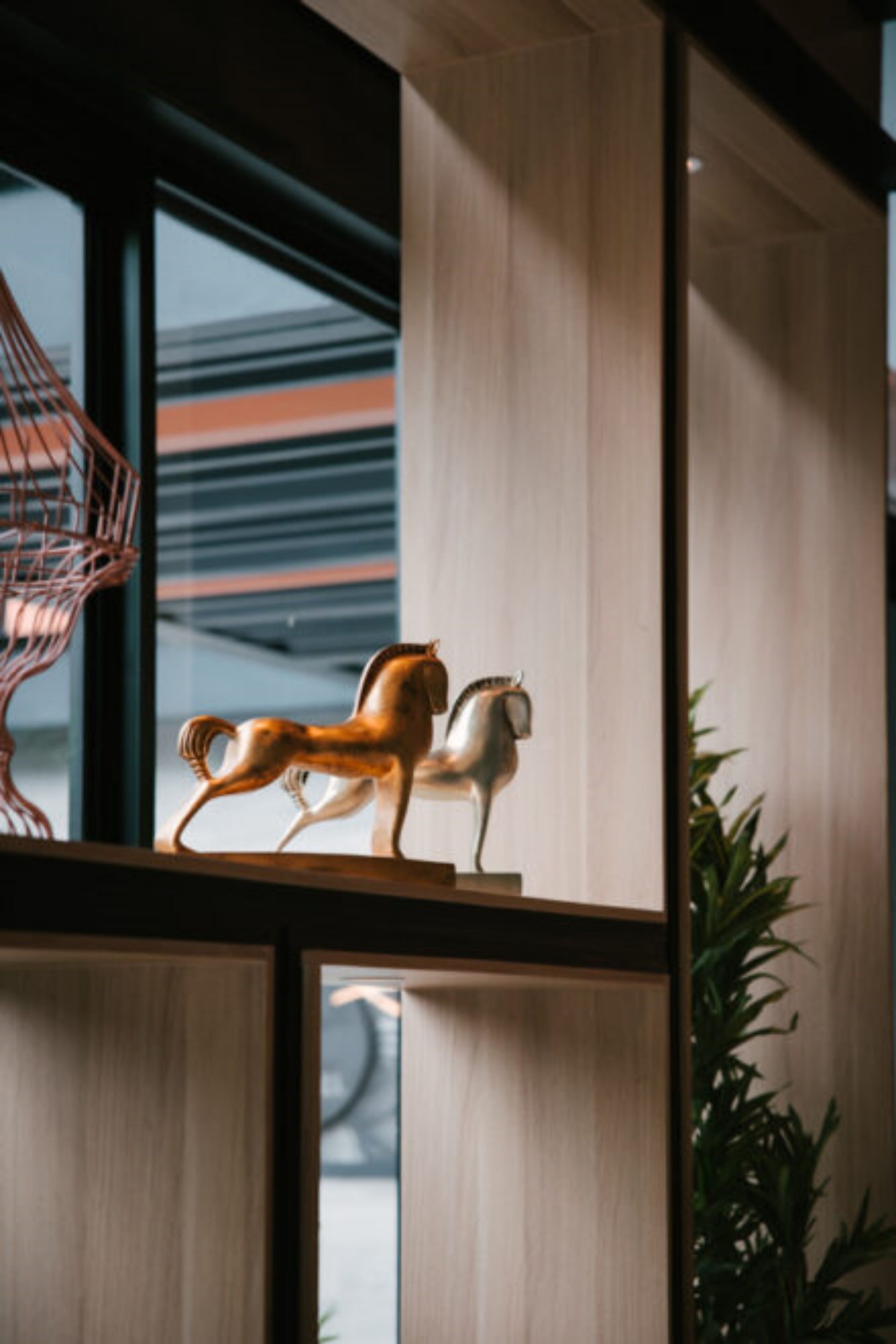 A modern interior with wooden paneling, a decorative horse sculpture, and a hanging light fixture.