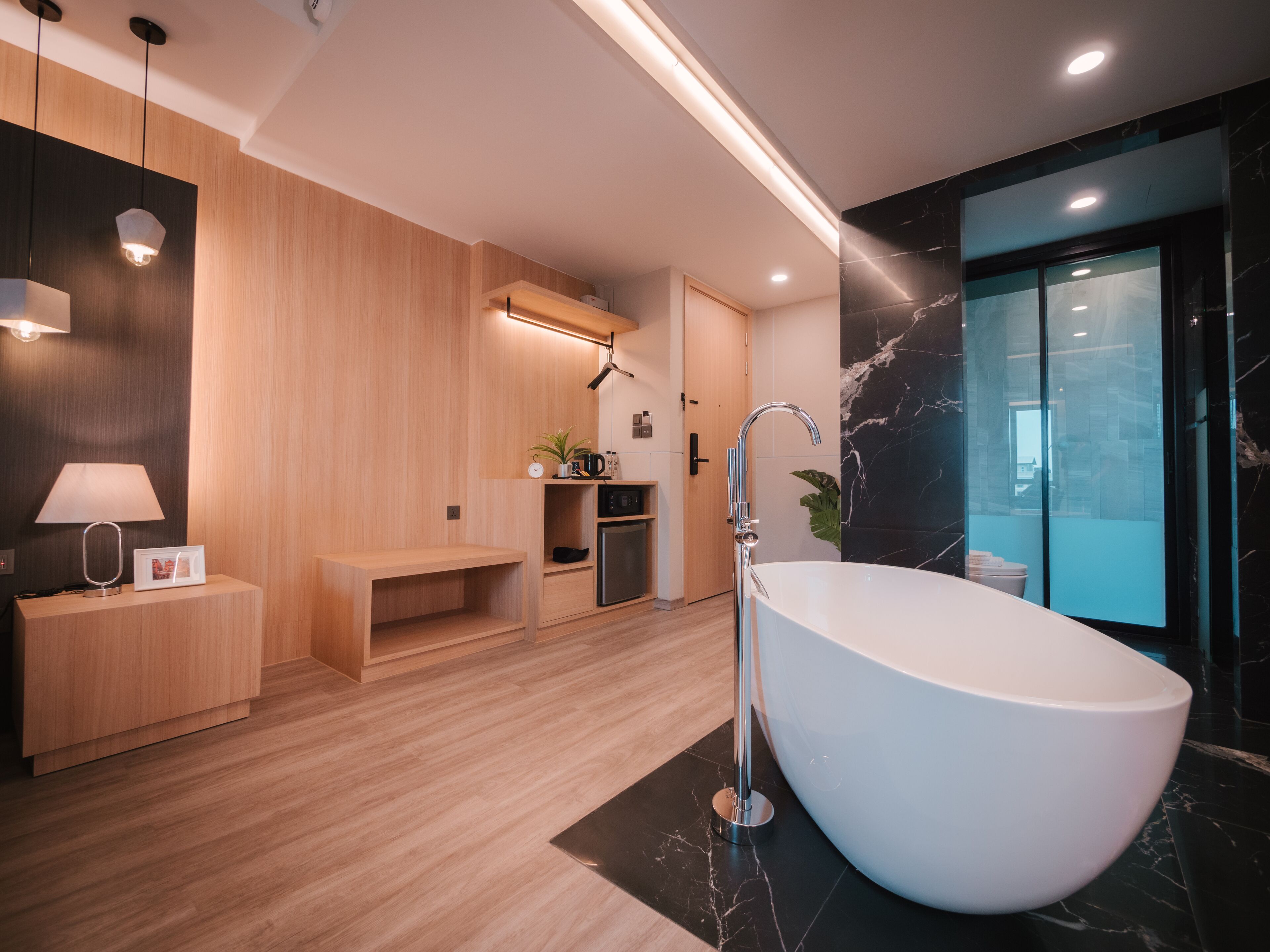 A modern bathroom with a freestanding bathtub, wooden vanity, and a glass shower enclosure.