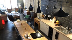 Una cocina moderna con una isla central, armarios de madera e iluminación colgante.