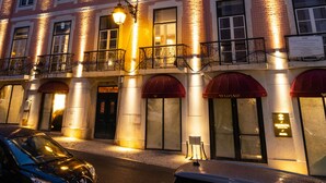 A multi-story hotel with a brick facade, multiple balconies, and illuminated windows.