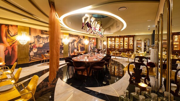 A luxurious dining area with a marble floor, round tables, and modern chairs.