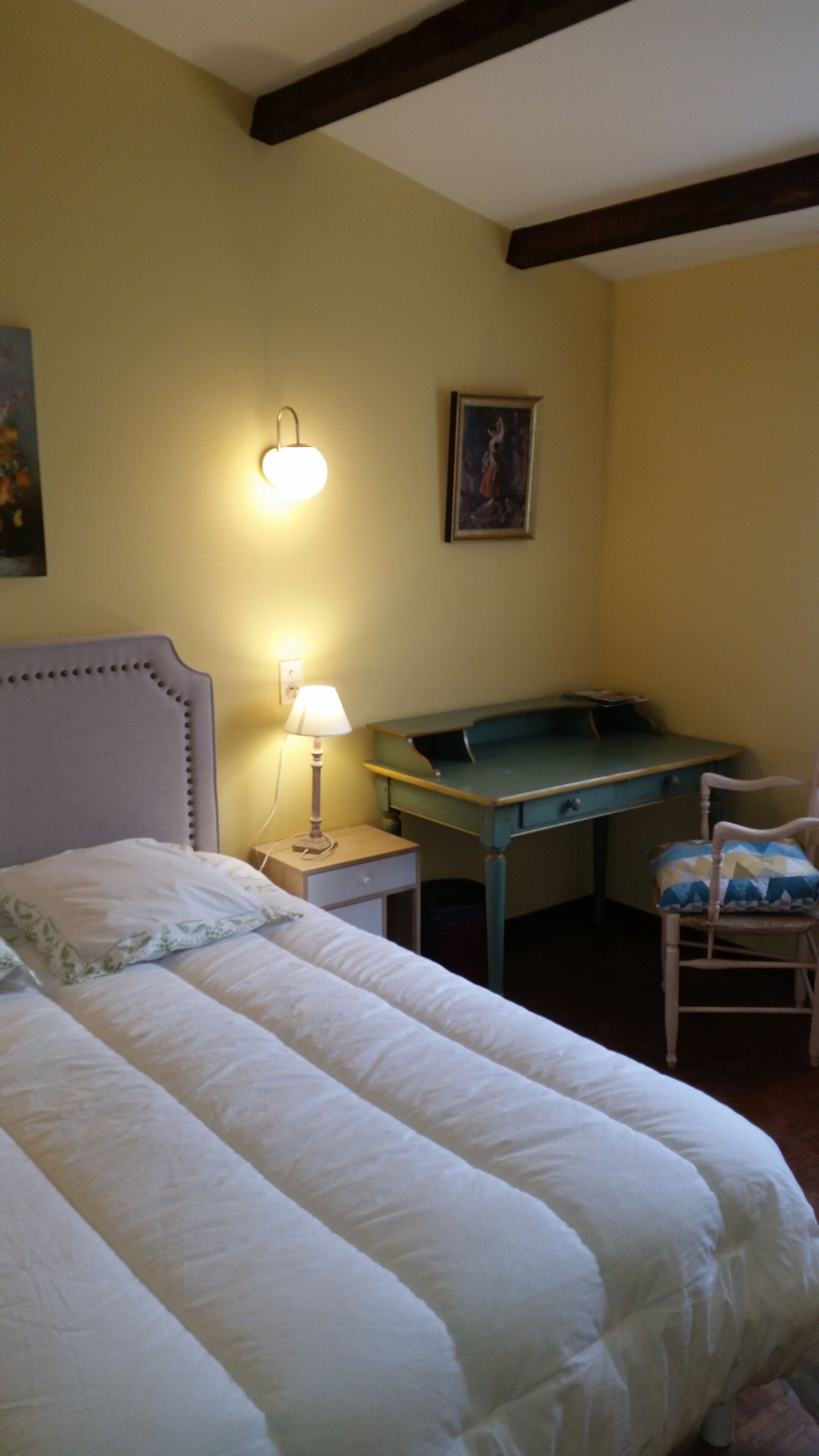 A bedroom with a bed, a desk, and a chair.