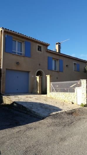 A two-story building with a stone facade, a large garage door, and a gated entrance. - Chambres d'hôtes Elisa & Etienne (Manosque)