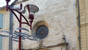 A historic building with a large arched entrance, a decorative emblem above the door, and a cobblestone pathway leading to it. - Chambres d'hôtes Elisa & Etienne (Manosque)